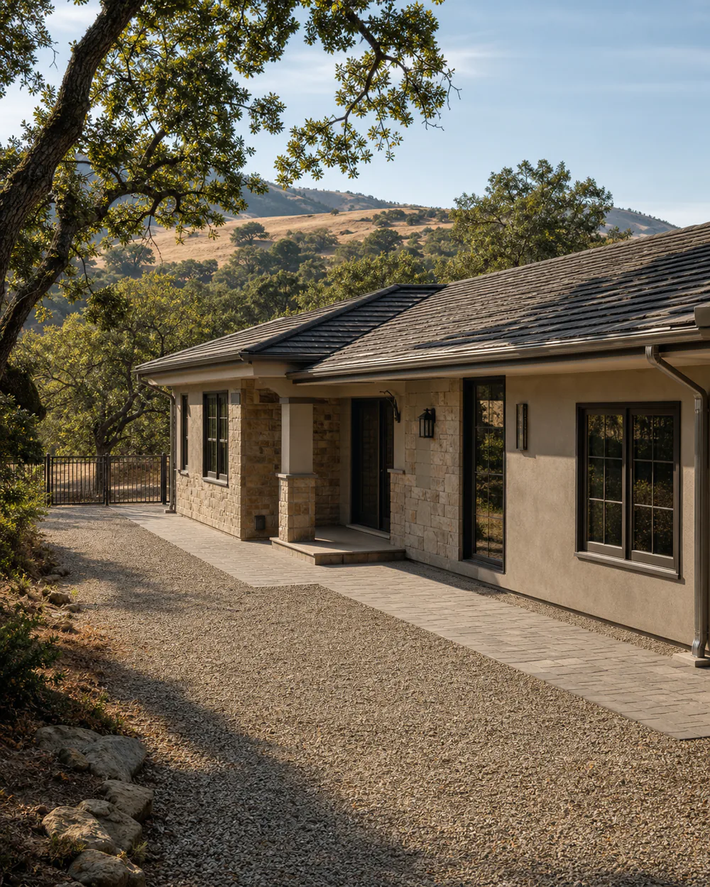 California foothill home with clean gutters and a wide plant-free gravel and paver area beside the structure