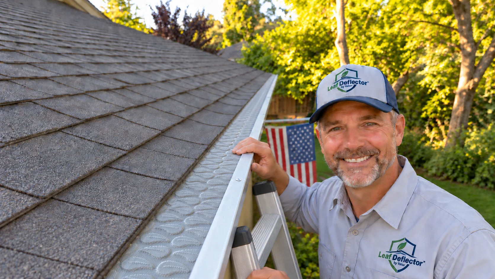 Contractor in Leaf Deflector workwear beside an installed gutter guard on a shingle roof